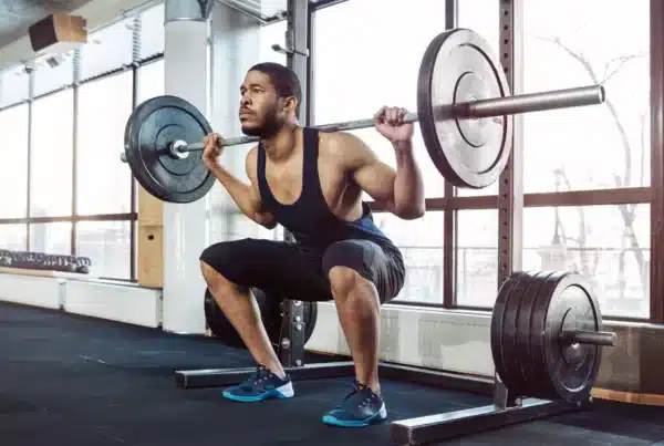 Athletic-Man-Performing-Squat-In-Empty-Gym.jpg