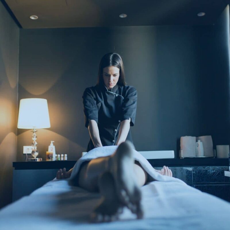 A licensed massage therapist giving a client a professional treatment, illustrating the physical benefits of massage therapy for home and work life.