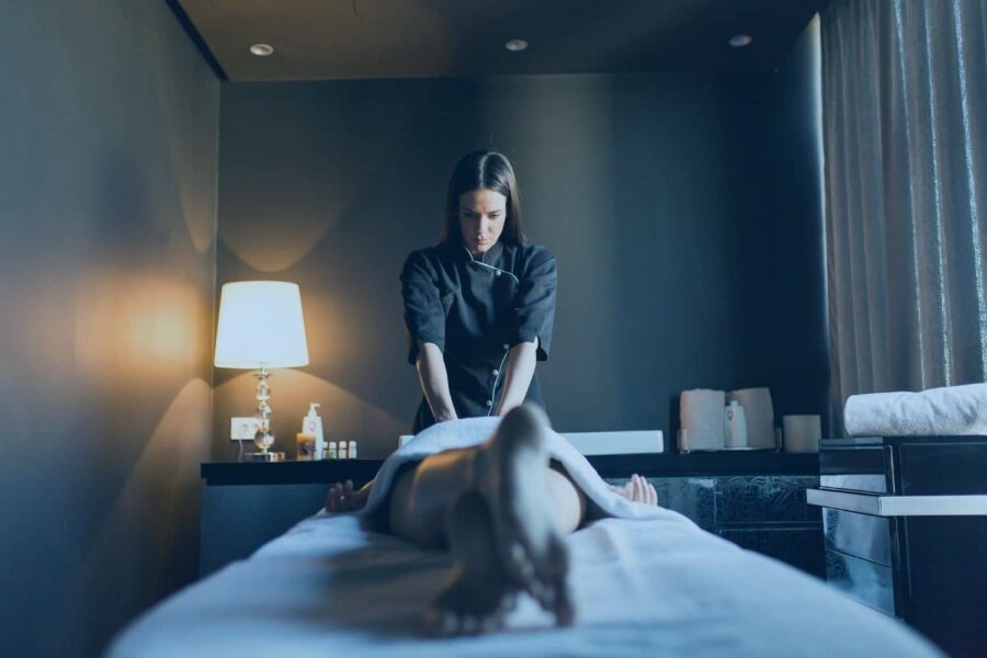A licensed massage therapist giving a client a professional treatment, illustrating the physical benefits of massage therapy for home and work life.
