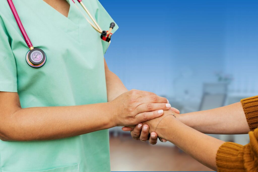 Healthcare provider holding hands with a patient in a supportive consultation, illustrating key questions to ask when diagnosed with breast cancer.