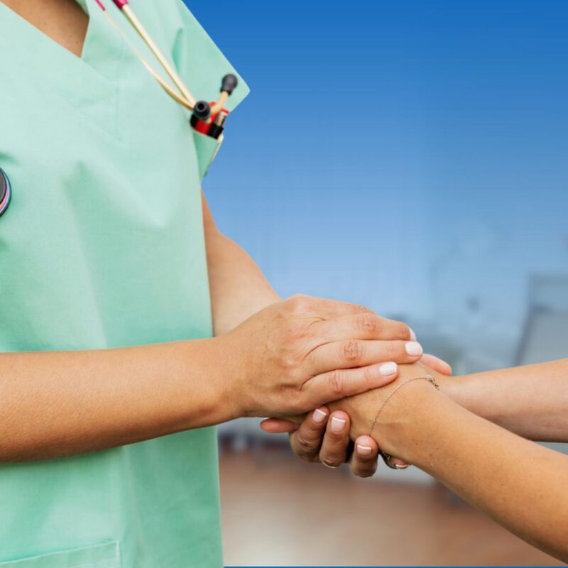 Healthcare provider holding hands with a patient in a supportive consultation, illustrating key questions to ask when diagnosed with breast cancer.